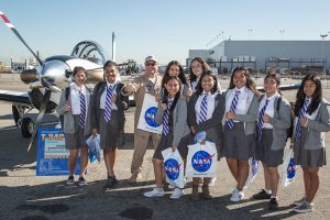 Group of girls holding NASA bags at an airport