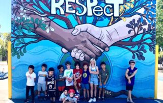 Kids standing in handball court painted Respect at Open Charter Magnet
