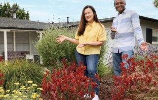 turf replacement Two people standing in a front yard that has been converted to xeriscaping